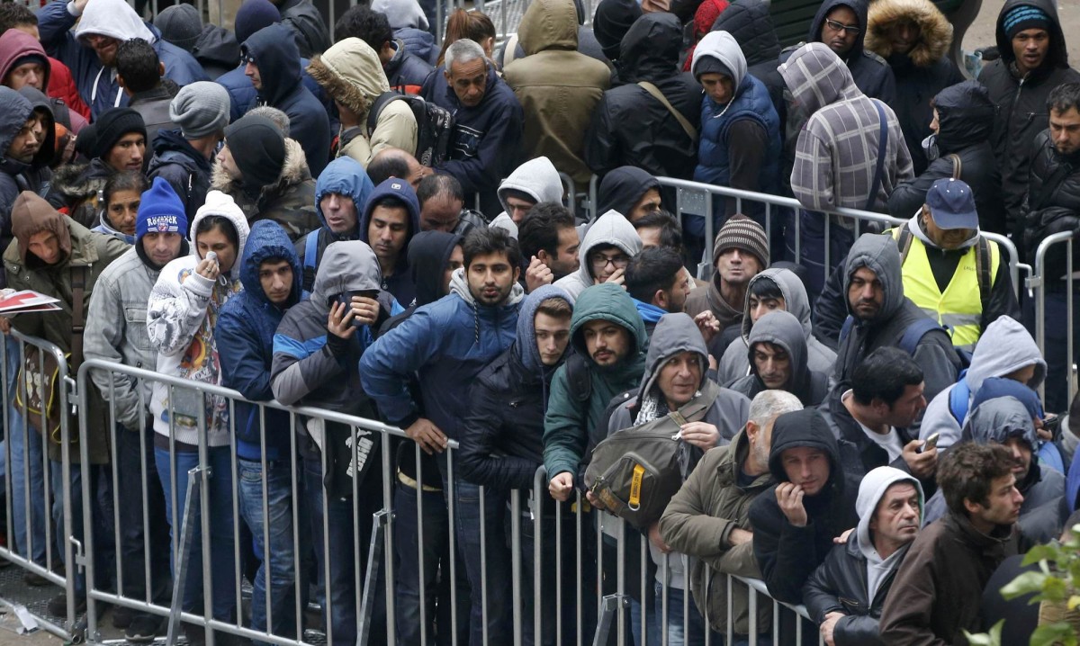 Migrants queue in the compound outside the Berlin Office of Health and Social Affairs (LAGESO) as they wait to register in Berlin, Germany, October 7, 2015. German authorities are struggling to cope with the roughly 10,000 refugees arriving every day, many fleeing conflict in the Middle East. The government expects 800,000 or more people to arrive this year and media say it could be up to 1.5 million. REUTERS/Fabrizio Bensch TPX IMAGES OF THE DAY