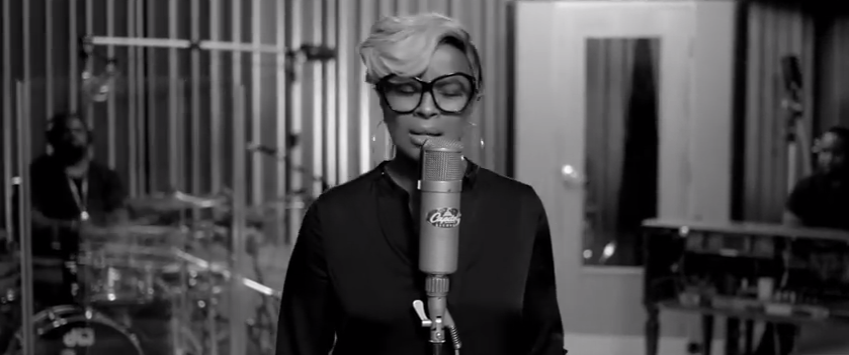 Photo noir et blanc de Mary J. Blige qui chante micro