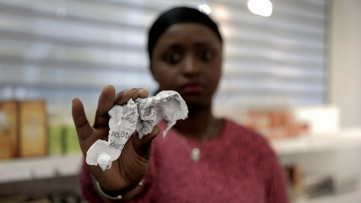 Anna Mendy qui tient dans la main ce qu'il reste de l'affiche.