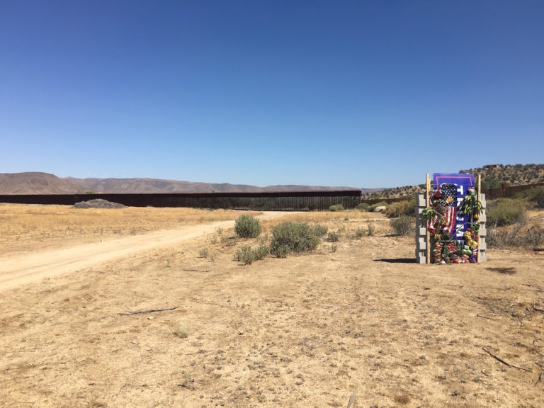 Vue d'ensemble petit mur face à grille imposante dans le désert américain