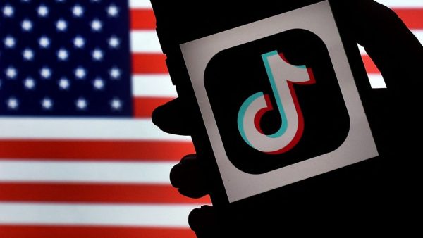 In this photo illustration, the social media application logo, TikTok is displayed on the screen of an iPhone on an American flag background on August 3, 2020 in Arlington, Virginia. - The US Senate voted on August 6, 2020, to bar TikTok from being downloaded onto US government employees' telephones, intensifying US scrutiny of the popular Chinese-owned video app. The bill passed by the Republican controlled Senate now goes to the House of Representatives, led by Democrats. (Photo by Olivier DOULIERY / AFP)